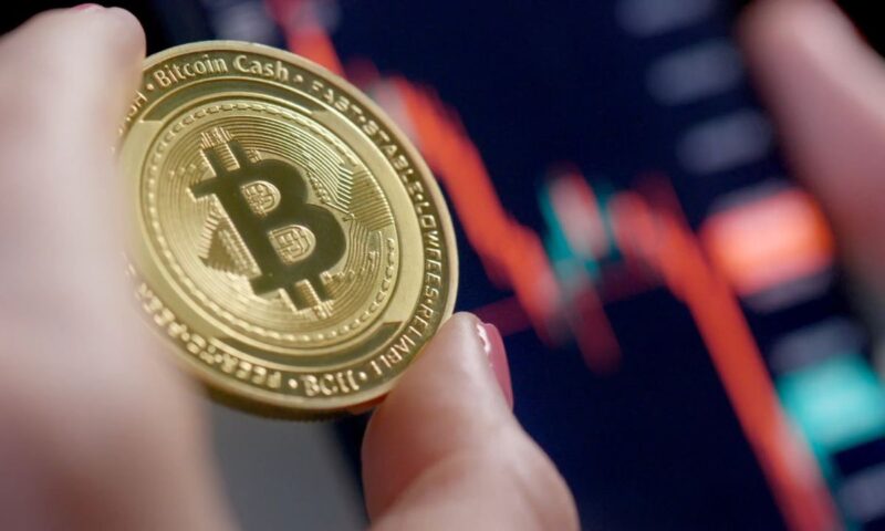 osoba drži kripto novčić u ruci