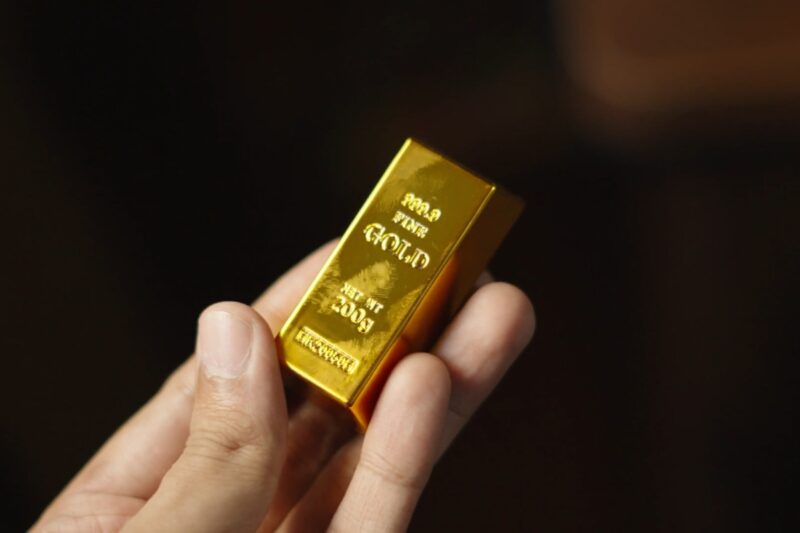 osoba drži zlatnu polugu u ruci