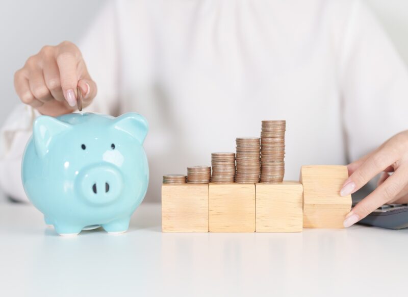 devojka ubacuje novac u kasicu prasicu