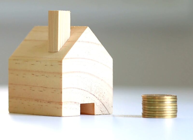 prikaz kuće i novca pored u kovanicama