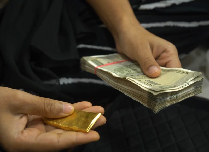 prikaz osobe koja drži novac i zlato u ruci