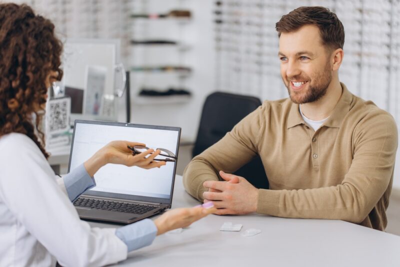 Zadovoljan kupac razgovara sa prodavcem tokom izbora proizvoda i razmene preporuka