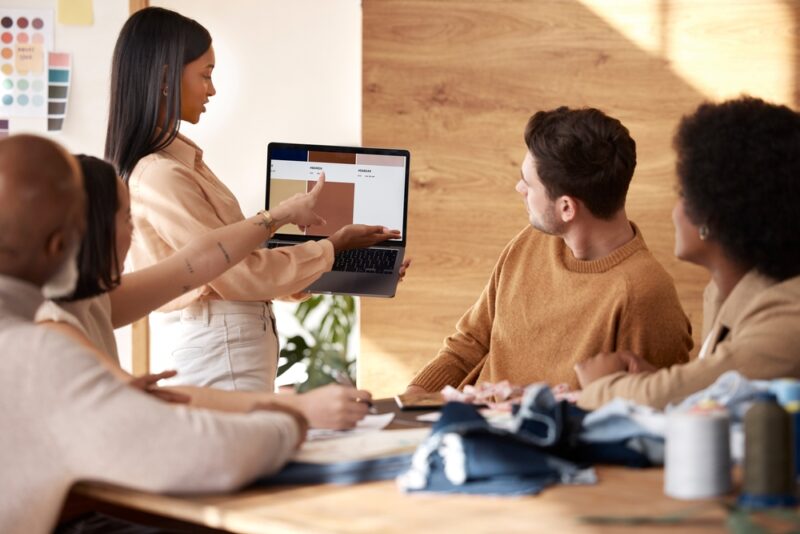 Tim analizira rezultate kampanje i strategiju na laptopu tokom sastanka