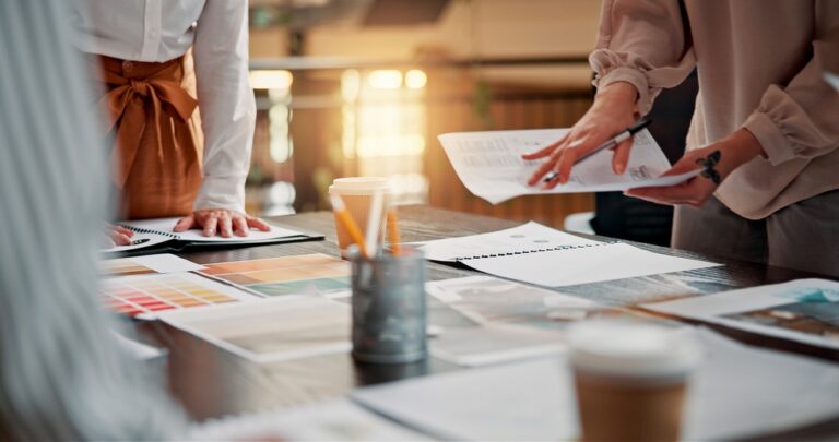 Tim planira strategiju brenda uz papire, paletu boja i kreativne materijale na stolu