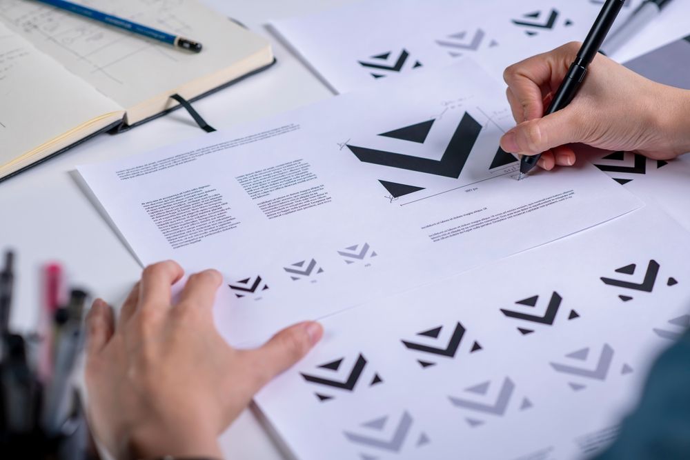 Dizajner kreira logotip i vizuelni identitet na radnom stolu