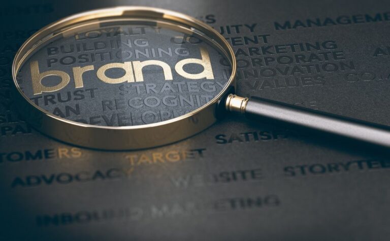 Lupa iznad reči brend na tamnoj marketinškoj pozadini
